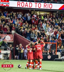 Image of female soccer players celebrating on the pitch in the stadium at TD Place in 2016