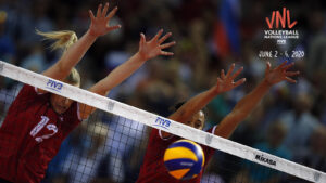 Image of 2 female volleyballers defending while in the air in front of the net