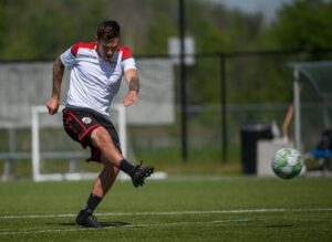 Image of an Atlético Ottawa FC players kicking a soccer ball